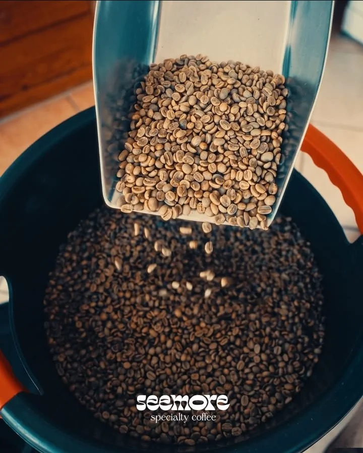 Green coffee beans poured over freshly roasted beans